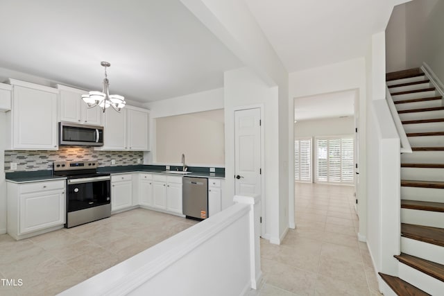 kitchen featuring light tile patterned flooring, dark countertops, a notable chandelier, appliances with stainless steel finishes, and tasteful backsplash
