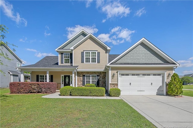 craftsman house featuring an attached garage, concrete driveway, a front yard, and stone siding
