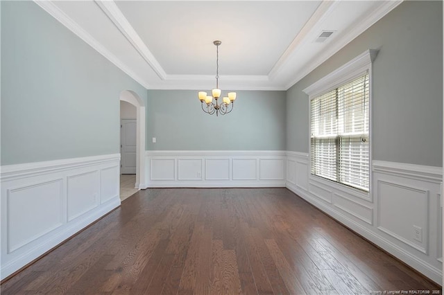 empty room featuring visible vents, arched walkways, an inviting chandelier, dark wood finished floors, and a tray ceiling