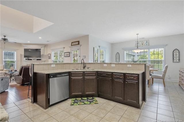 kitchen with dark brown cabinetry, a ceiling fan, dishwasher, a sink, and open floor plan