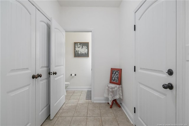 bathroom featuring tile patterned floors, baseboards, and toilet