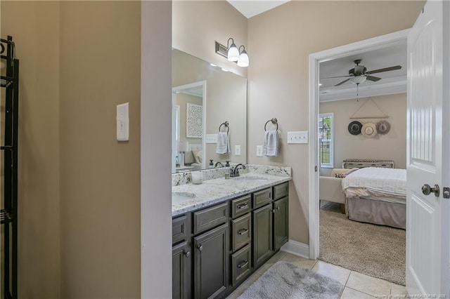 ensuite bathroom featuring double vanity, tile patterned flooring, connected bathroom, ceiling fan, and a sink