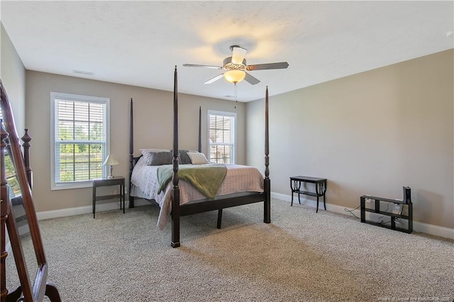 carpeted bedroom featuring visible vents, baseboards, and a ceiling fan