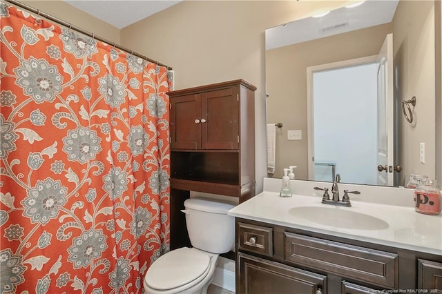 full bathroom featuring a shower with shower curtain, vanity, visible vents, and toilet