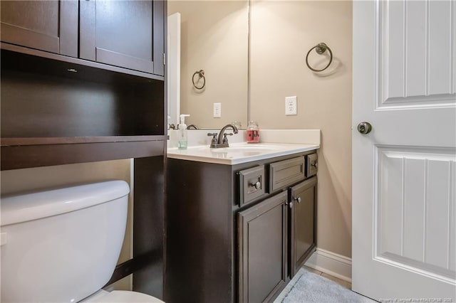 half bathroom with vanity and toilet