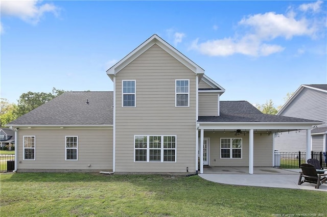 rear view of house with a patio, a yard, and fence