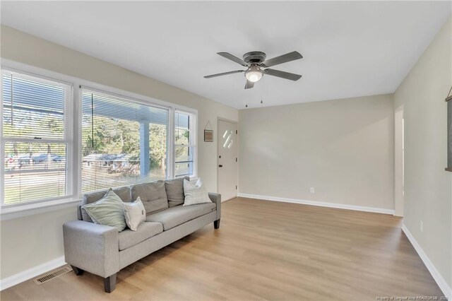 7517 Seaton Pl, Fayetteville, NC 28303 - living room with light wood-style floors, visible vents, baseboards, and ceiling fan