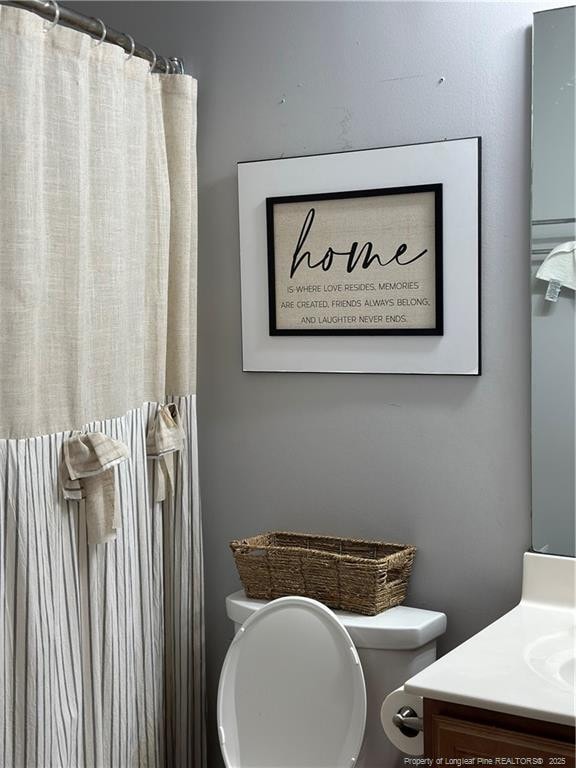 full bath featuring vanity and toilet
