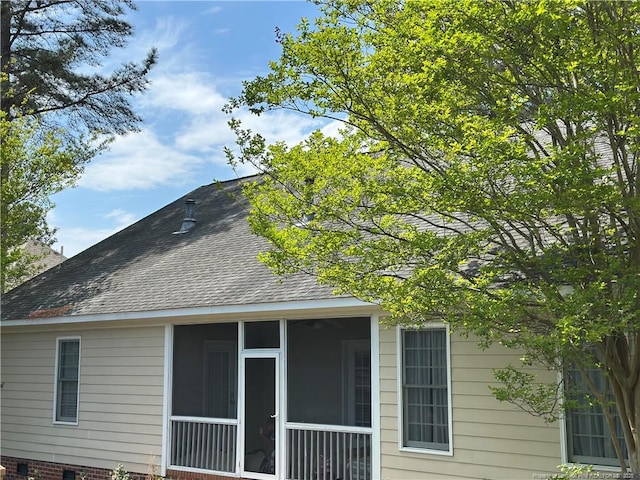 view of property exterior with a sunroom and roof with shingles