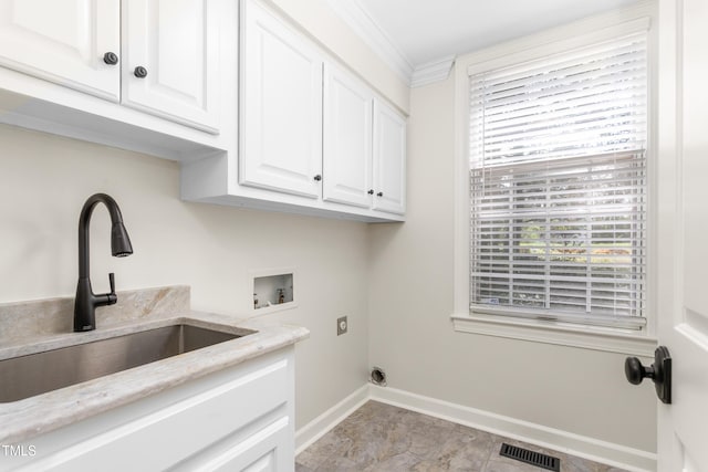 washroom with cabinet space, a sink, hookup for a washing machine, hookup for an electric dryer, and visible vents