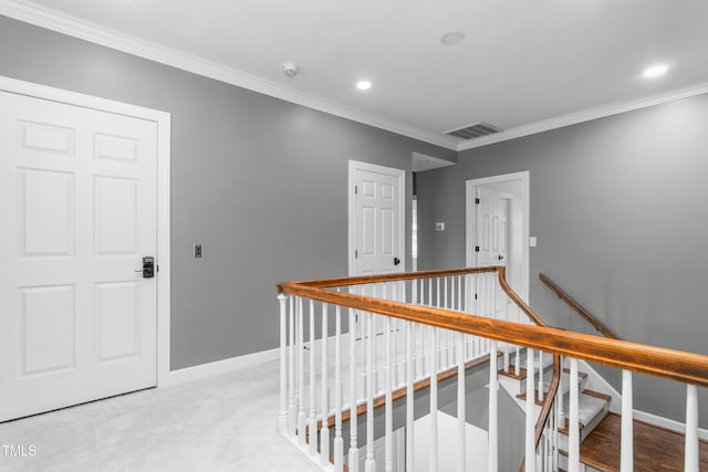 hallway with baseboards, ornamental molding, an upstairs landing, and visible vents