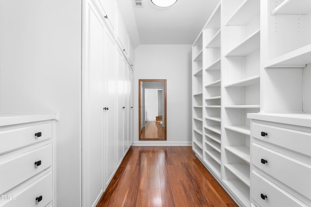spacious closet with dark wood-style floors