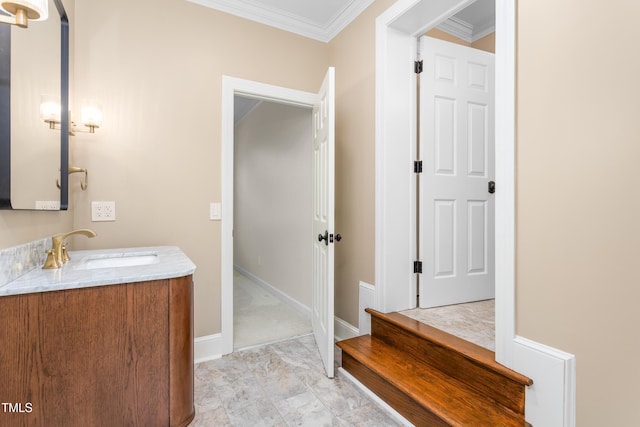 bathroom with baseboards, ornamental molding, and vanity