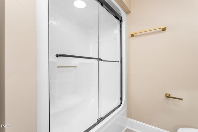 bathroom with baseboards, an enclosed shower, and toilet