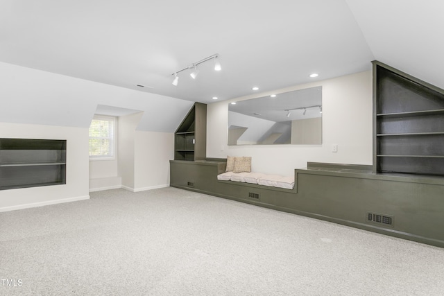 unfurnished living room with baseboards, carpet flooring, rail lighting, and visible vents