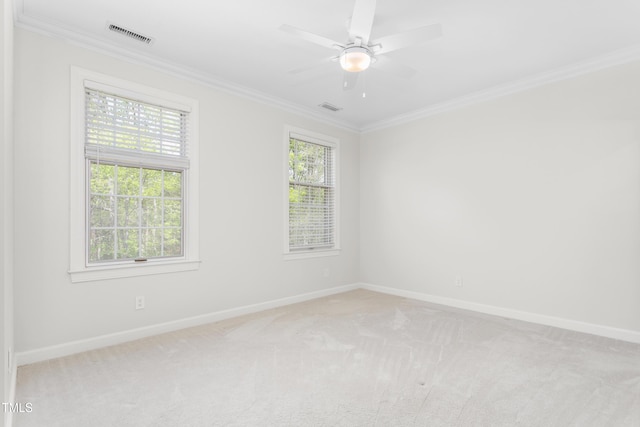 unfurnished room with crown molding, baseboards, light colored carpet, and visible vents