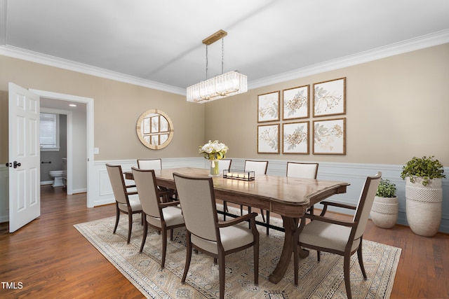 dining room featuring wainscoting, ornamental molding, and wood finished floors