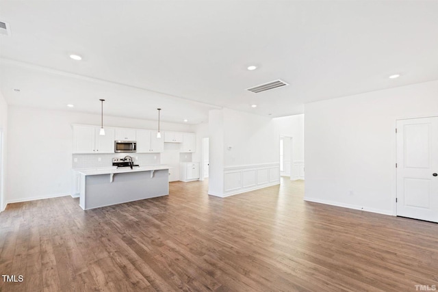 unfurnished living room featuring recessed lighting, visible vents, and wood finished floors
