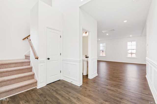 interior space featuring recessed lighting, wainscoting, visible vents, a decorative wall, and wood finished floors