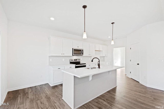 kitchen featuring a sink, tasteful backsplash, appliances with stainless steel finishes, and wood finished floors