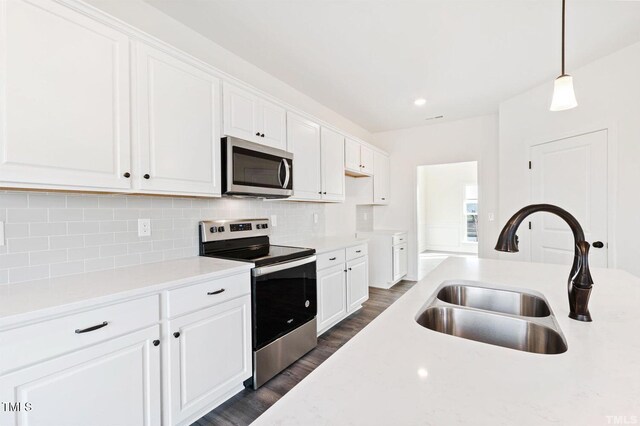 kitchen with stainless steel appliances, white cabinets, and a sink