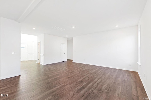 empty room featuring dark wood-style flooring, baseboards, and recessed lighting