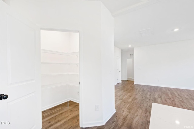 spare room featuring baseboards, recessed lighting, and wood finished floors