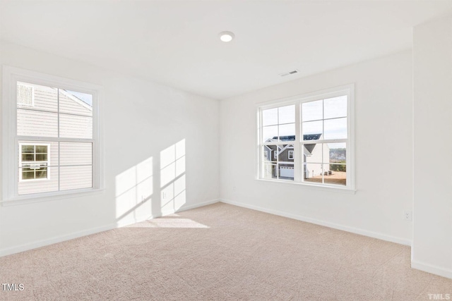spare room with plenty of natural light, visible vents, and carpet floors
