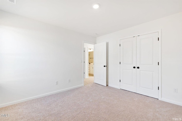 unfurnished bedroom featuring a closet, carpet flooring, and baseboards
