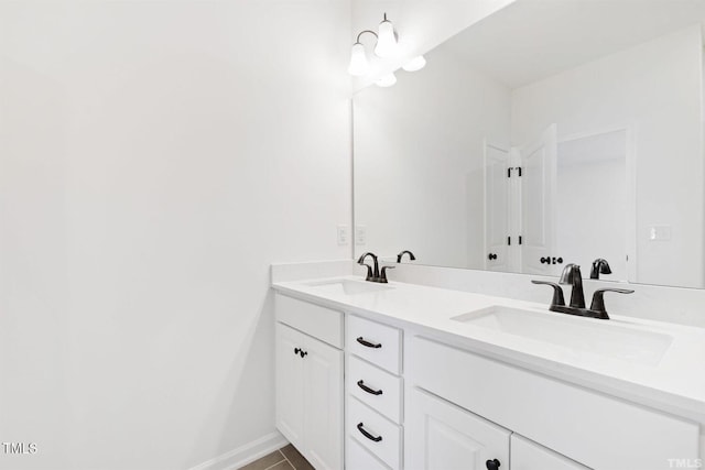 bathroom with tile patterned flooring, double vanity, baseboards, and a sink