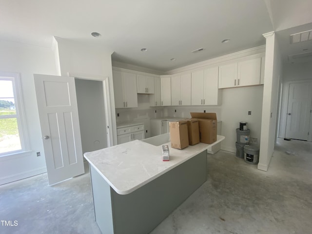 102 Rae Dr, Pikeville, NC 27863 - kitchen with white cabinets, unfinished concrete floors, and a center island