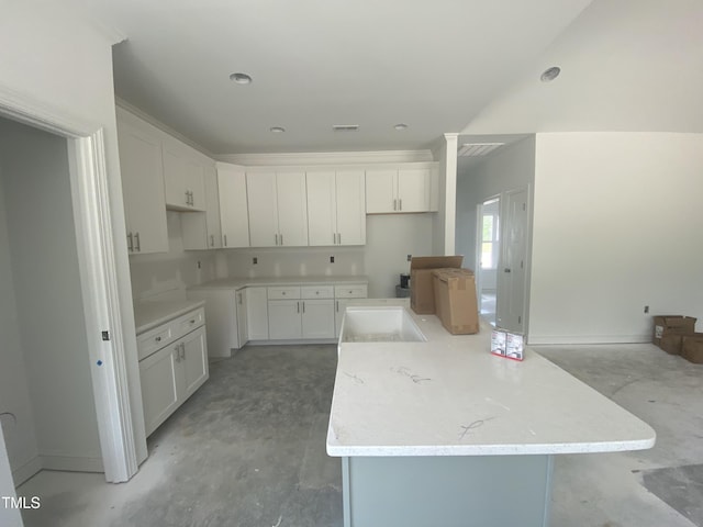 102 Rae Dr, Pikeville, NC 27863 - kitchen with a center island, white cabinets, and concrete flooring