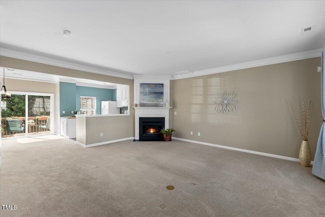 unfurnished living room with baseboards, ornamental molding, and carpet