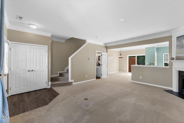 unfurnished living room featuring carpet floors, stairs, baseboards, visible vents, and ornamental molding