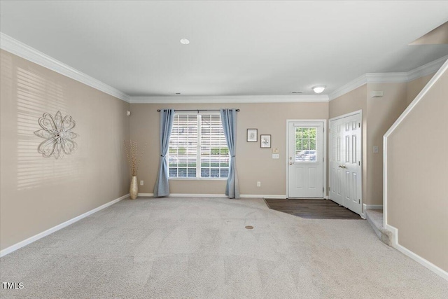 carpeted entryway featuring crown molding and baseboards