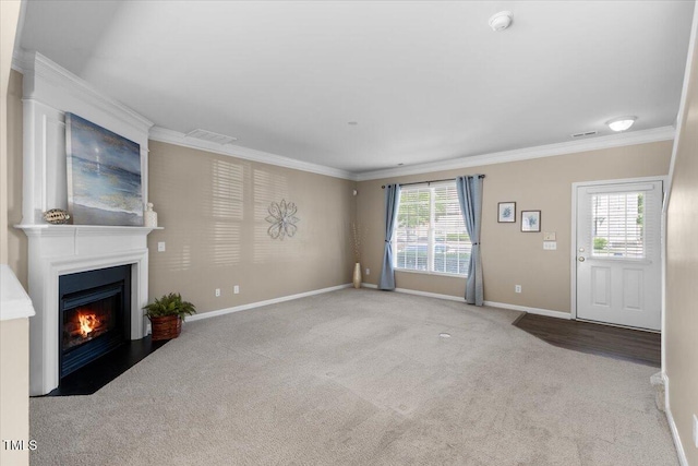 unfurnished living room with crown molding, carpet flooring, baseboards, a fireplace with flush hearth, and visible vents