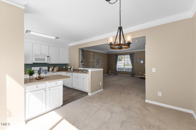 kitchen with crown molding, a peninsula, white appliances, and light colored carpet