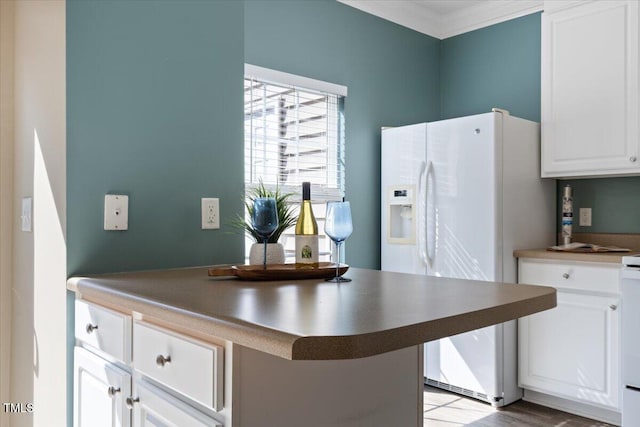 kitchen with ornamental molding, a breakfast bar, dark countertops, white cabinetry, and white fridge with ice dispenser