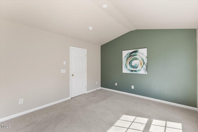 unfurnished room with baseboards, carpet flooring, and lofted ceiling