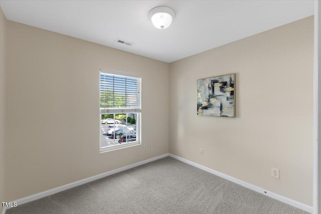 carpeted empty room featuring baseboards and visible vents
