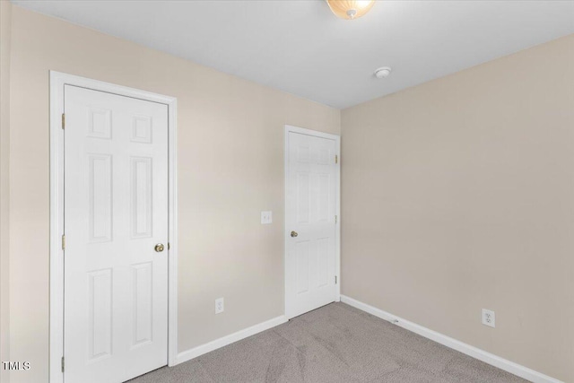 unfurnished bedroom with carpet flooring and baseboards