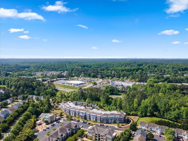 bird's eye view with a wooded view