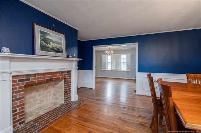 211 Edgewood Ave, Clinton, NC 28328 - unfurnished dining area with a notable chandelier, ornamental molding, a wainscoted wall, and wood finished floors