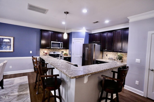 126 Willow Weald Ct, Fuquay Varina, NC 27526 - kitchen with stainless steel appliances, a breakfast bar area, light stone counters, crown molding, and tasteful backsplash