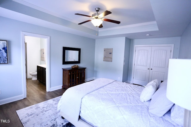 126 Willow Weald Ct, Fuquay Varina, NC 27526 - bedroom with dark wood-type flooring, a tray ceiling, baseboards, crown molding, and a closet