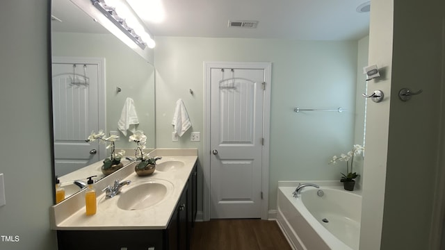 126 Willow Weald Ct, Fuquay Varina, NC 27526 - bathroom featuring double vanity, wood finished floors, and a garden tub