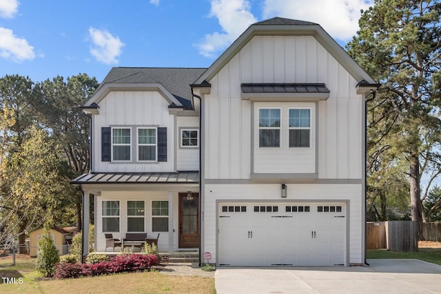 modern farmhouse style home featuring board and batten siding, an attached garage, a standing seam roof, and fence