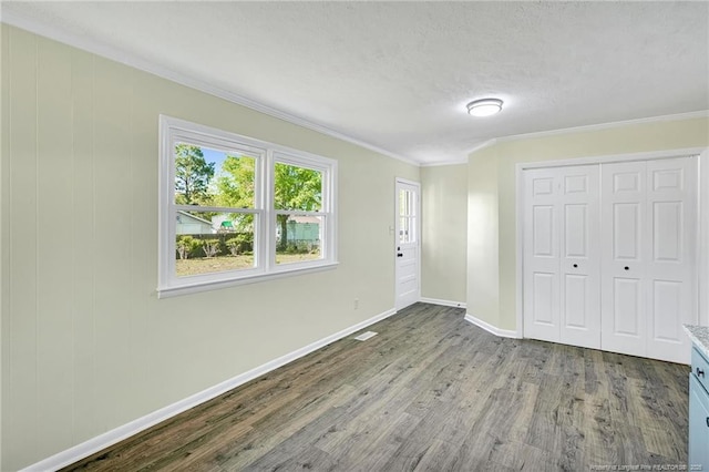 3014 Akron Dr, Hope Mills, NC 28348 - unfurnished bedroom with a textured ceiling, baseboards, ornamental molding, and wood finished floors