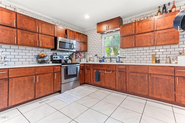 2102 Courtland Dr, Sanford, NC 27330 - kitchen with backsplash, appliances with stainless steel finishes, a sink, and light countertops