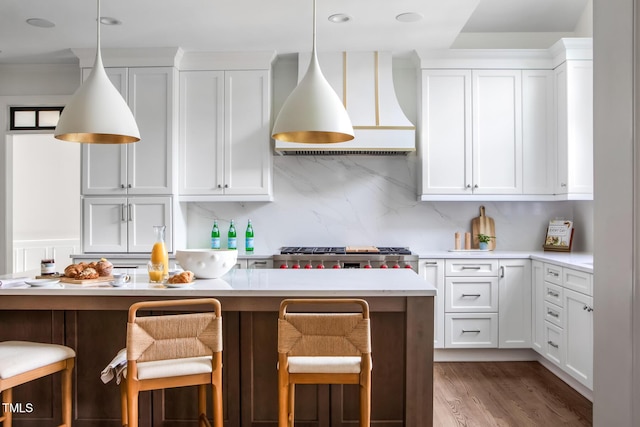 123 Trellingwood Dr, Morrisville, NC 27560 - kitchen with custom exhaust hood, a breakfast bar, light countertops, white cabinets, and pendant lighting